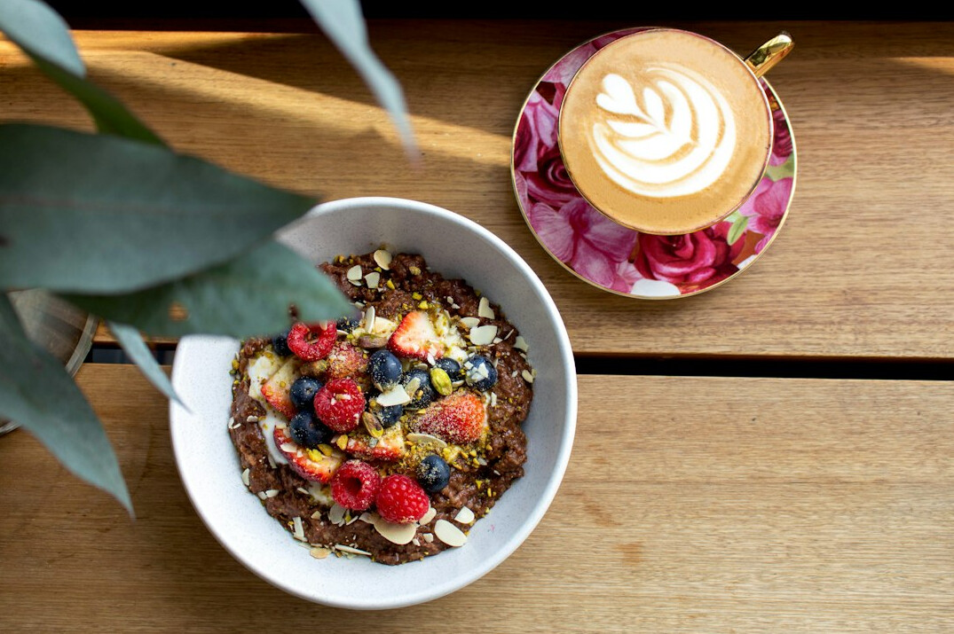 Colorful healthy breakfast bowl with fruit and nuts on a wooden table