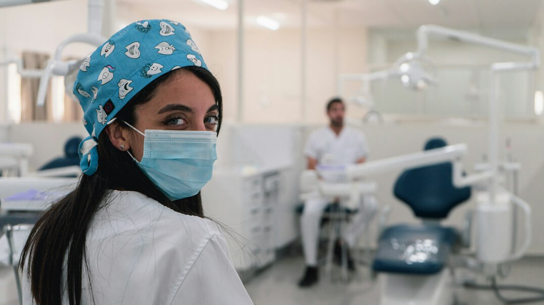 Health professional with a stethoscope smiling in a bright clinic