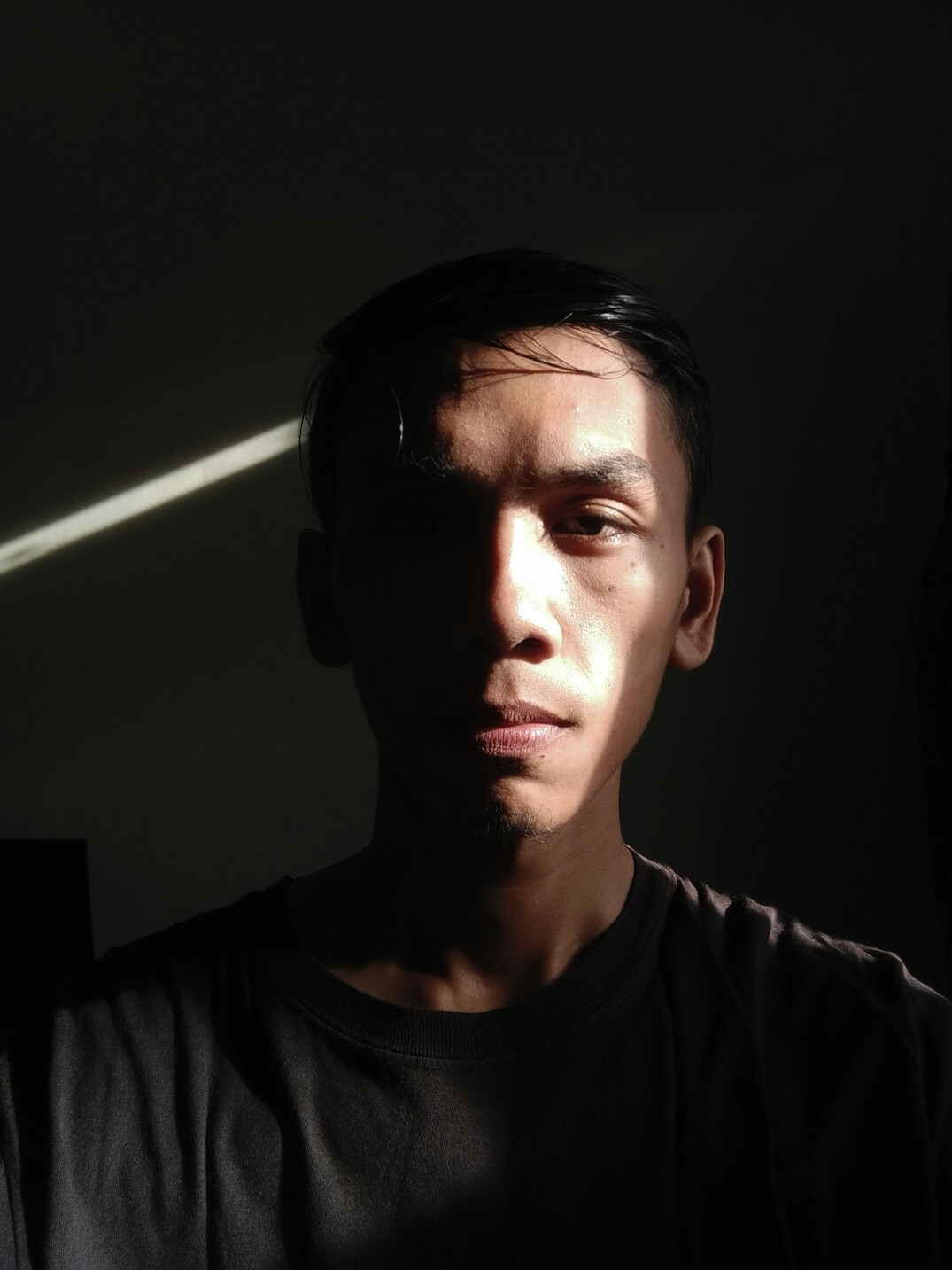 Portrait of a man in a dark shirt looking at the camera